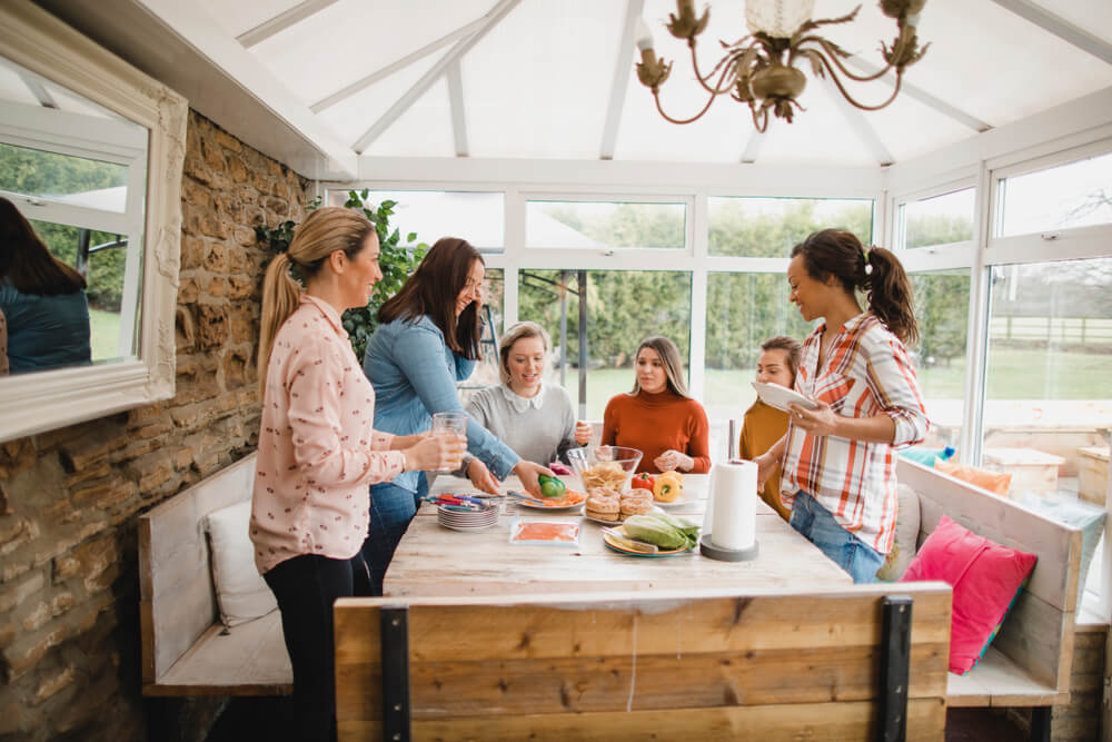 Mulheres ao redor de uma mesa de chá da tarde simples.