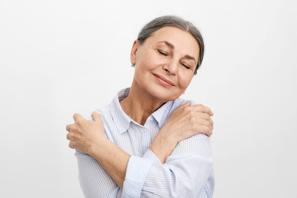 Senhora se abraçando.