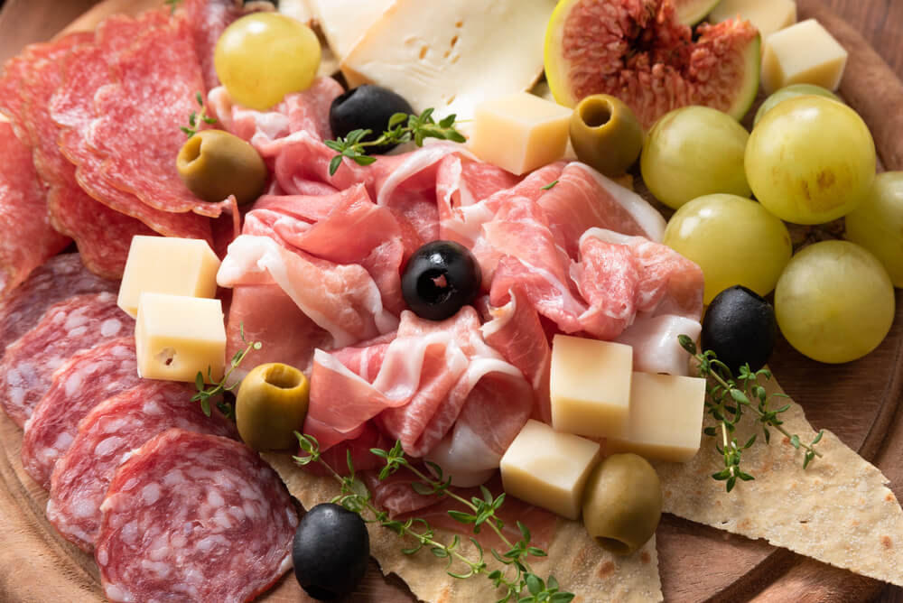 Tábua de frios com embutidos, queijos, azeitonas e figos.
